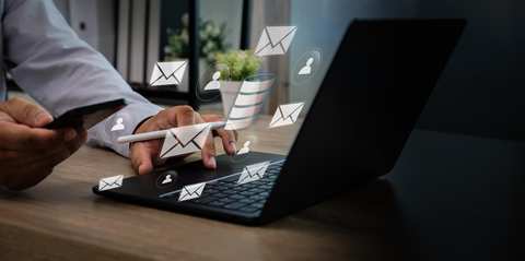 Profesional gestionando estrategia de email marketing desde el ordenador y el móvil